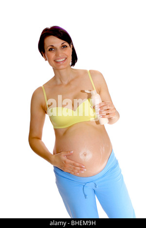 Pregnant woman putting cream on her belly to prevent stretch marks Stock Photo