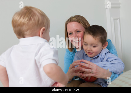 Woman signing the word 'Ball' in American Sign Language while communicating with her son Stock Photo