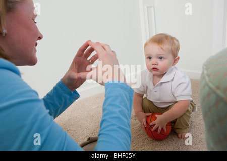 Woman signing the word 'Ball' in American Sign Language while communicating with her son Stock Photo