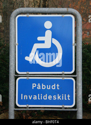 Sign in a Danish car park showing a slot reserved for a disabled person's car, the car must display an official 'disabled' sign
