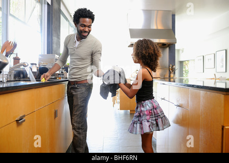Father and daughter washing dishes