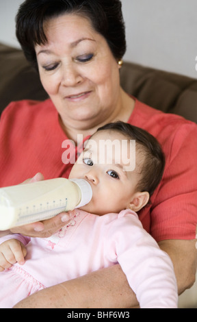 Hispanic grandmother feeding baby Stock Photo