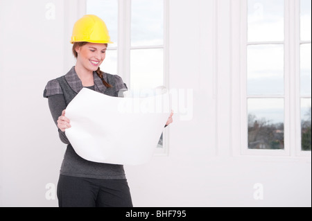 Young architect in a white room is reading a plan Stock Photo