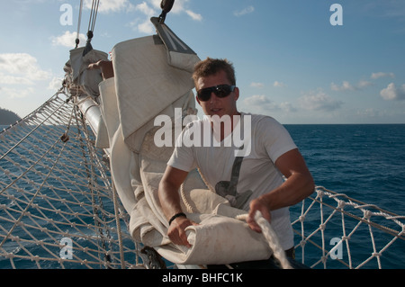 Crew of a sailing tall ship, the Solway Lass, at work while cruising on the Great Barrier Reef Stock Photo