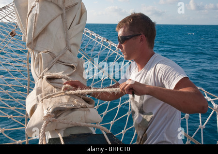 Crew of a sailing tall ship, the Solway Lass, at work while cruising on the Great Barrier Reef Stock Photo