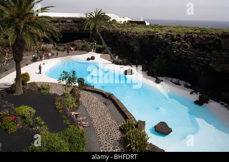 Swimming pool with palm trees near a volcanic cave, Jameos del Agua, hollow lava tunnel, architect Cesar Manrique, UNESCO Biosph Stock Photo