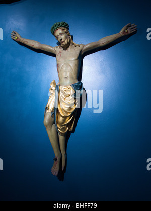 religious art sad looking Jesus hanging on a blue wall in a museum in Luik, Belgium Stock Photo