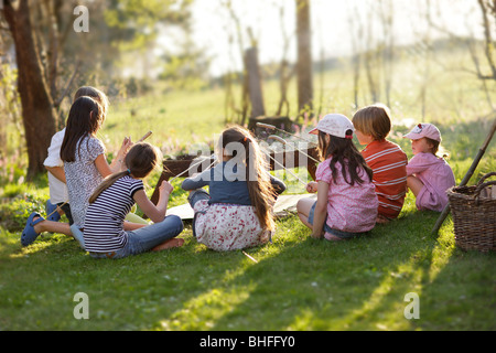 Children barbecueing sausages, Munsing, Bavaria, Germany Stock Photo