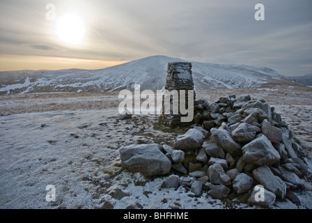 Trig point and wind shelter on the summit of Clough Head in the Lake District in winter Stock Photo