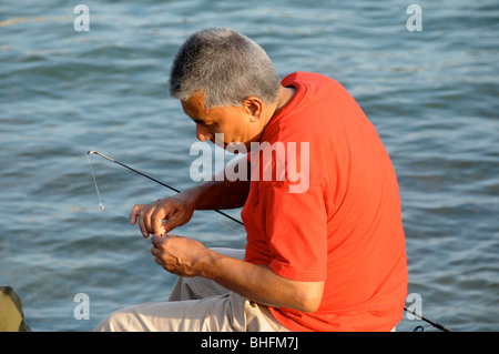 Fisherman baiting hook. Stock Photo