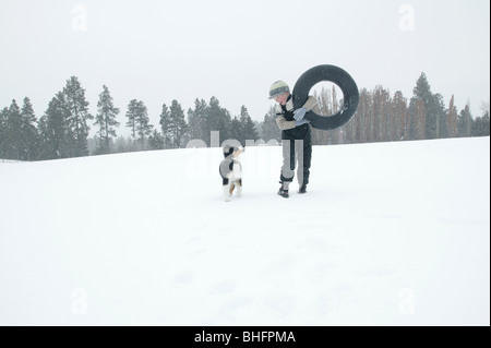 boy with Australian  shepherd puppy in  snow                                boy walking in snow with Australian  shepherd