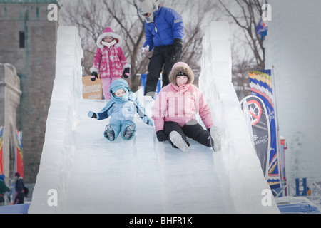 A woman and her daughter ride an ice slide at the Quebec Winter Carnival (Carnaval de Quebec) in Quebec city, Stock Photo