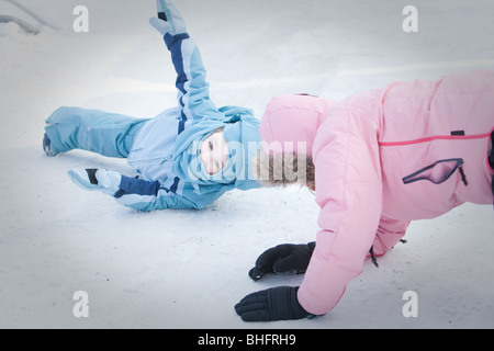 A woman and her daughter fall as they ride an ice slide at the Quebec Winter Carnival (Carnaval de Quebec) in Quebec city, Stock Photo