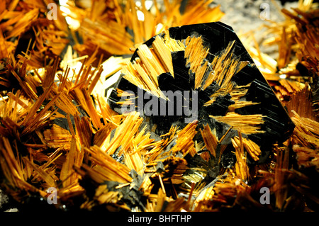 Rutile (TiO2) crystals growing on hematite (Fe2O3). Stock Photo