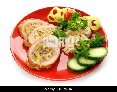 Stuffed turkey meat with vegetable garnish on red plate Stock Photo