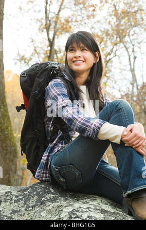 Young woman sitting on boulder Stock Photo