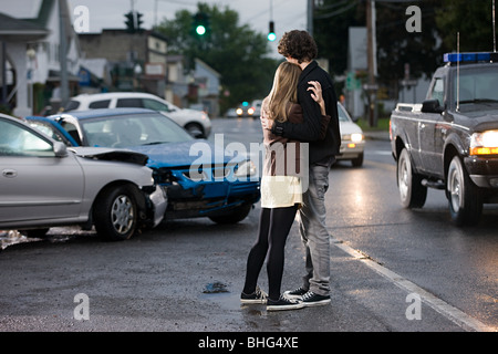Young couple looking at crashed cars Stock Photo