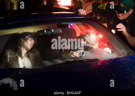 Police officer looking at crashed car Stock Photo