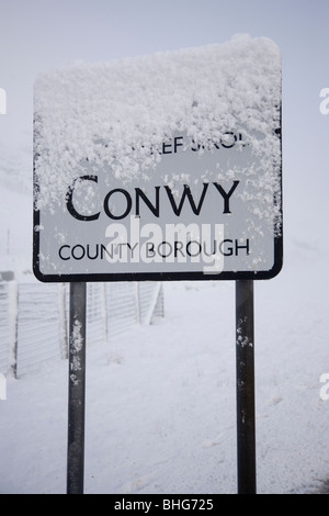 Snow covered Conwy County Borough road sign on the top of the Crimea Pass, on the A470 trunk road as you leave Gwynedd, Wales Stock Photo