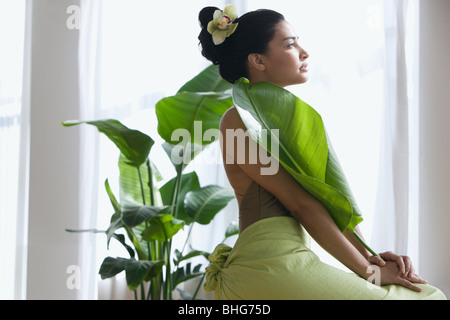 Young woman holding a large leaf Stock Photo