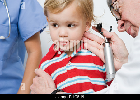 Doctor looking in boys ear Stock Photo