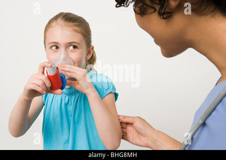 Girl taking asthma inhaler Stock Photo