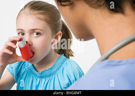 Girl taking asthma inhaler Stock Photo