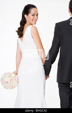 The bride and groom stand holding hands near the railing under the ...