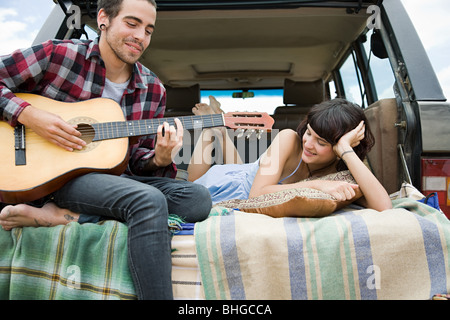 Young man playing guitar to girlfriend Stock Photo