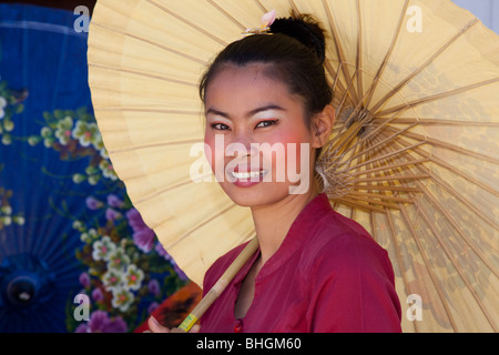 Female painter painting parasol designs, Bor Bo Sang Factory Umbrella Village, Sankampaeng Road, Chiang Mai, Northern Thailand Stock Photo