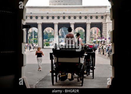 A Viennese Fiaker horse carriage drives through the gates at Hofburg Palace in Vienna Austria Stock Photo