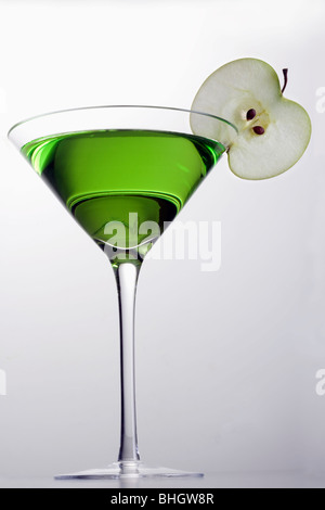 Apple Martini mixed drink with apple slice garnish on grey background Stock Photo