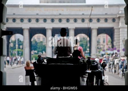 A Viennese Fiaker horse carriage drives through the gates at Hofburg Palace in Vienna Austria Stock Photo