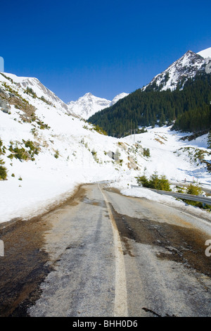 Road through mountains, with snow melting Stock Photo