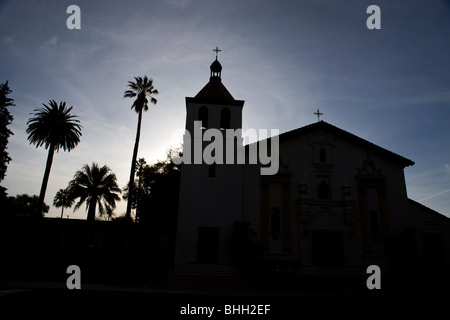 Silhouette of Mission Santa Clara de Asís, Mission Church, at sunset with palm trees, Santa Clara University, Santa Clara Stock Photo