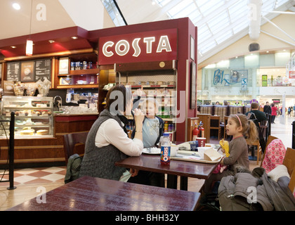 A mother and her two children having a drink at Costa Coffee, Grafton Centre Shopping Mall, Cambridge UK Stock Photo