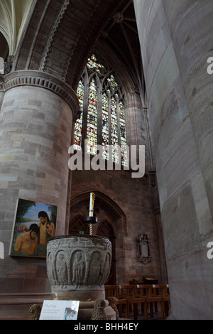 The West window and stone Font at Hereford Cathedral,both framed by the enormous columns framing both subjects. Stock Photo