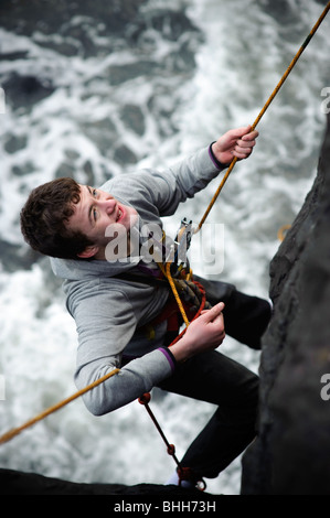 Learning the ropes: Aberystwyth university student abseiling on the sea wall, training for climbing , Wales UK Stock Photo
