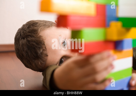 8 year old boy playing with colorful cubes on the floor Stock Photo