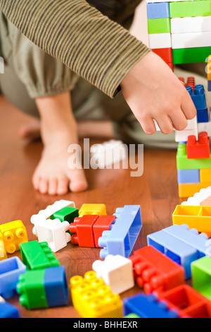 8 year old boy playing with colorful cubes on the floor Stock Photo