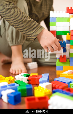 8 year old boy playing with colorful cubes on the floor Stock Photo