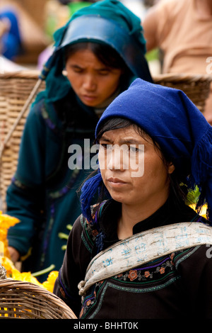 Hani women carrying bamboo shopping baskets at a market in Yunnan, China. Stock Photo