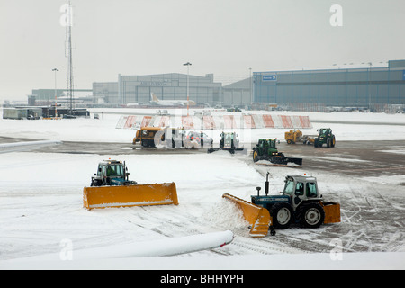 UK, England, Manchester Airport, workers clearing snow and de-icing taxiway Stock Photo