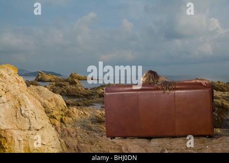 couple sit on couch with sea view Stock Photo