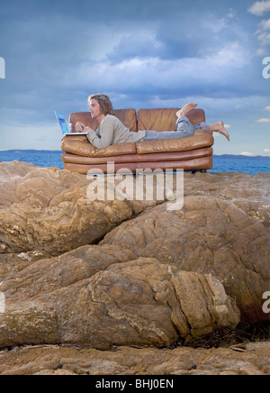 man with laptop on couch at beach Stock Photo