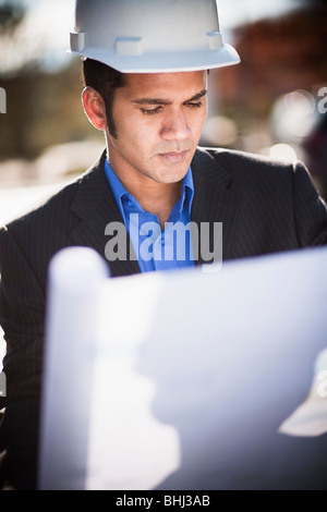 Engineer looking at blueprints outside Stock Photo