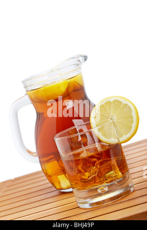 Ice tea pitcher and glasss with lemon and icecubes on wooden background. Focus at front and shallow depth of field Stock Photo