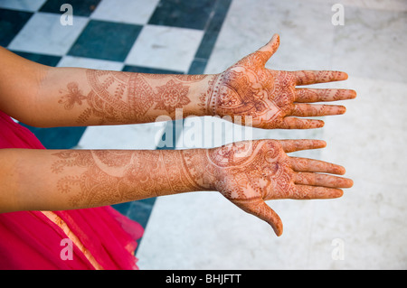 A new bride holds out her hands that are decorated in henna tattoos. Stock Photo