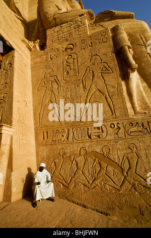 Temple guard and reliefs at Abu Simbel's Temple of Ramesses II, Egypt Stock Photo