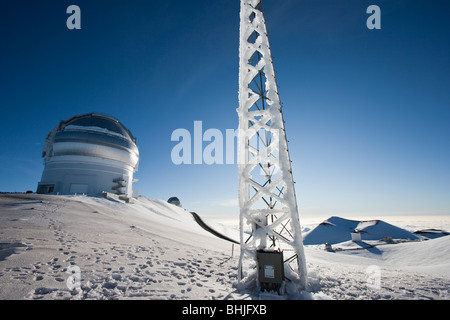 Summit of Mauna Kea with ice covered radio tower and Canada France Hawaii Telescope (CFHT) on left. Stock Photo